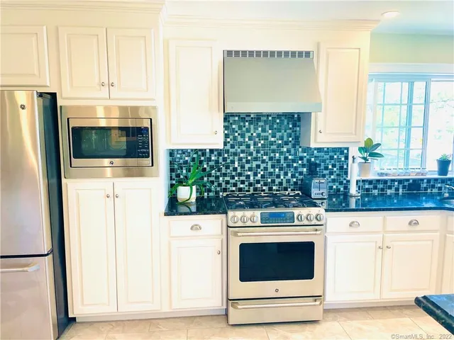 a kitchen with granite countertop a stove sink and cabinets