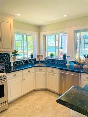 a kitchen with granite countertop a stove sink and cabinets