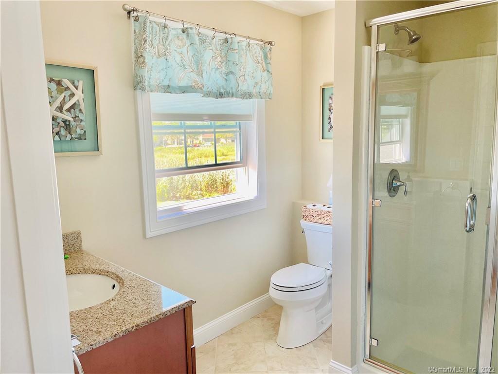 28 Beach Road West Old Saybrook, CT 06475 - Photo 4 of 22 a bathroom with a granite countertop toilet a sink and a shower