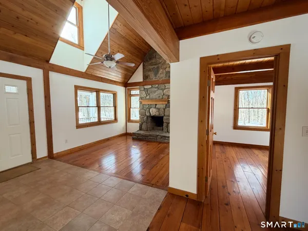 a view of a livingroom with wooden floor and a kitchen