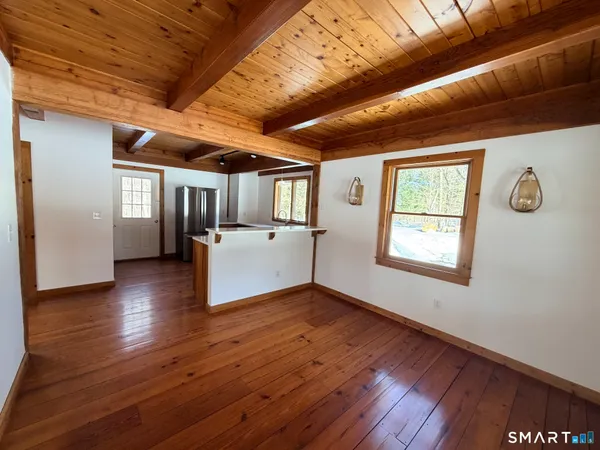 a kitchen with stainless steel appliances granite countertop a refrigerator a sink and wooden floors