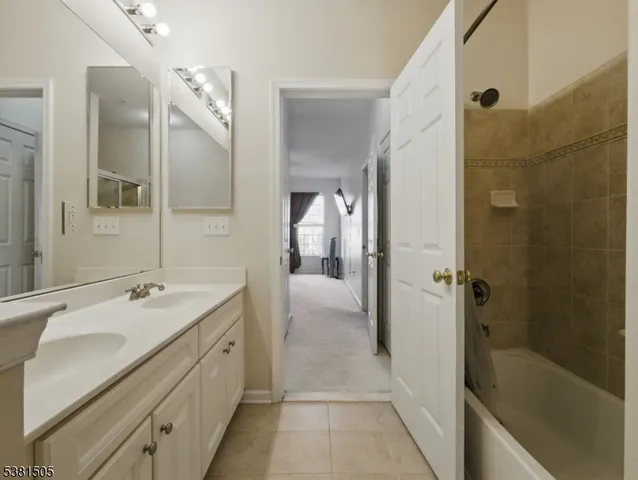 a en suite bathroom with a granite countertop sink mirror and shower