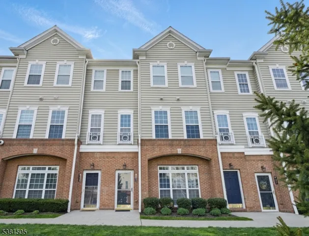 a front view of a house with yard and green space
