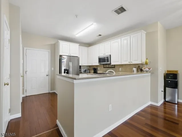 a kitchen with stainless steel appliances granite countertop a refrigerator sink and cabinets