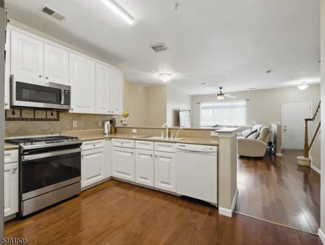 a kitchen with a sink dishwasher a stove and a microwave oven with cabinets