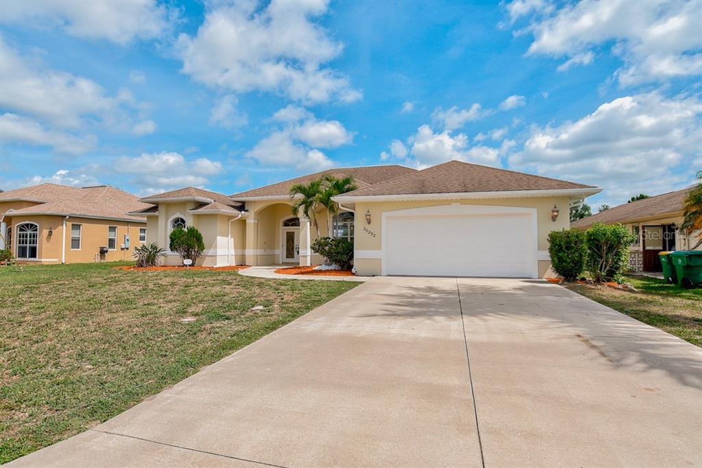 26292 Hong Kong Road Punta Gorda, FL 33983 - Photo 1 of 1 a view of a white house next to a yard with big trees