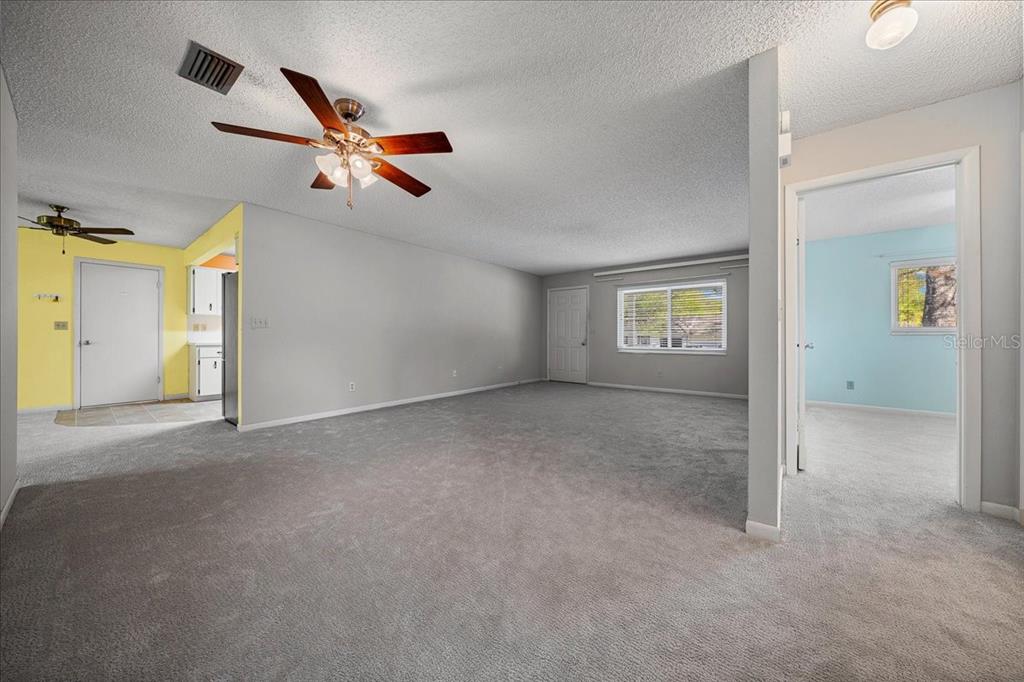 8702 Southwest 94 Street, Unit A Ocala, FL 34481 - Photo 11 of 55 an empty room with a ceiling fan and windows