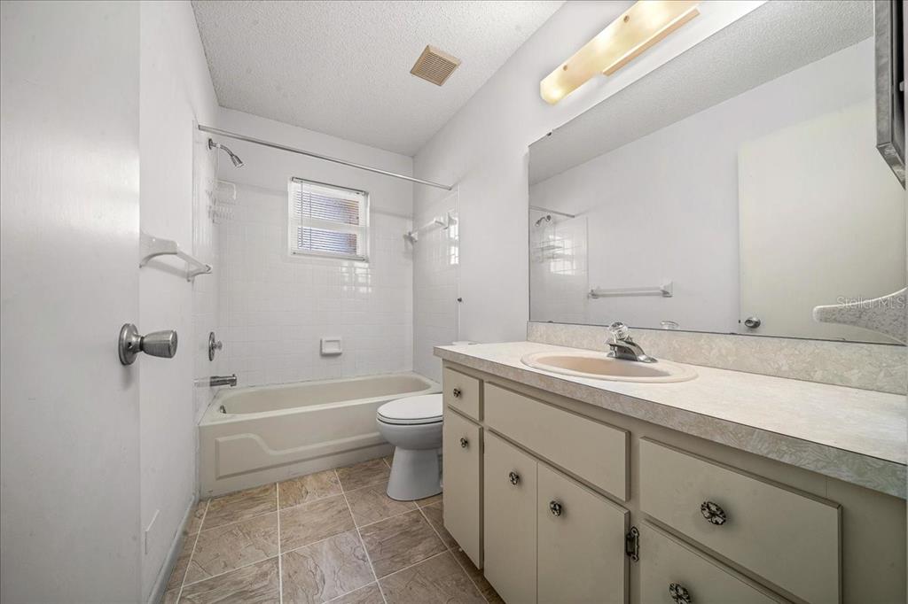8702 Southwest 94 Street, Unit A Ocala, FL 34481 - Photo 14 of 55 a bathroom with a granite countertop sink toilet and shower