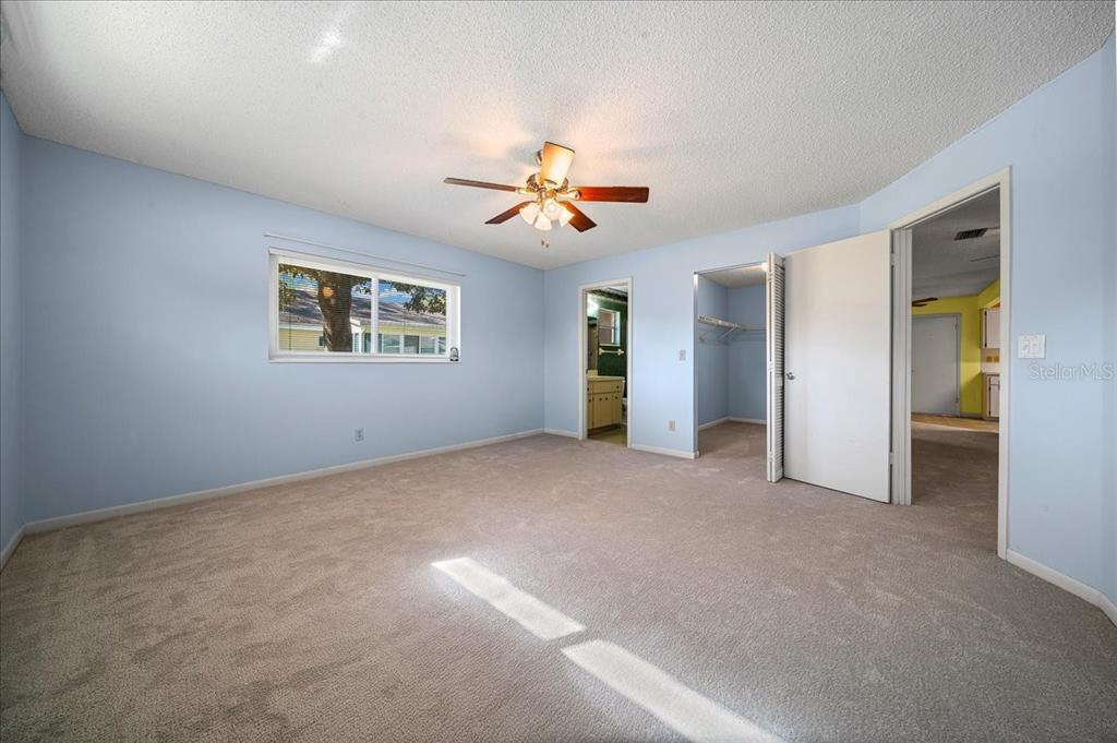 8702 Southwest 94 Street, Unit A Ocala, FL 34481 - Photo 21 of 55 a view of a big room with chandelier fan and windows