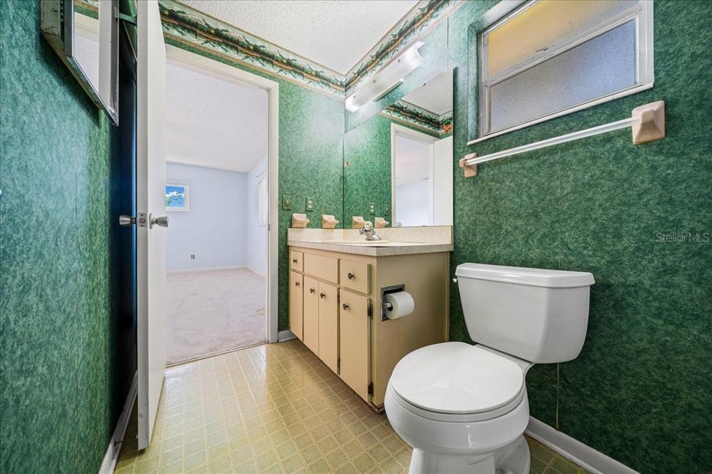 8702 Southwest 94 Street, Unit A Ocala, FL 34481 - Photo 25 of 55 a bathroom with a sink a toilet and a mirror