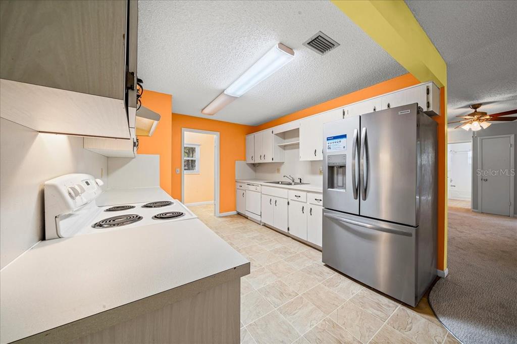 8702 Southwest 94 Street, Unit A Ocala, FL 34481 - Photo 30 of 55 a kitchen with stainless steel appliances a refrigerator sink and cabinets