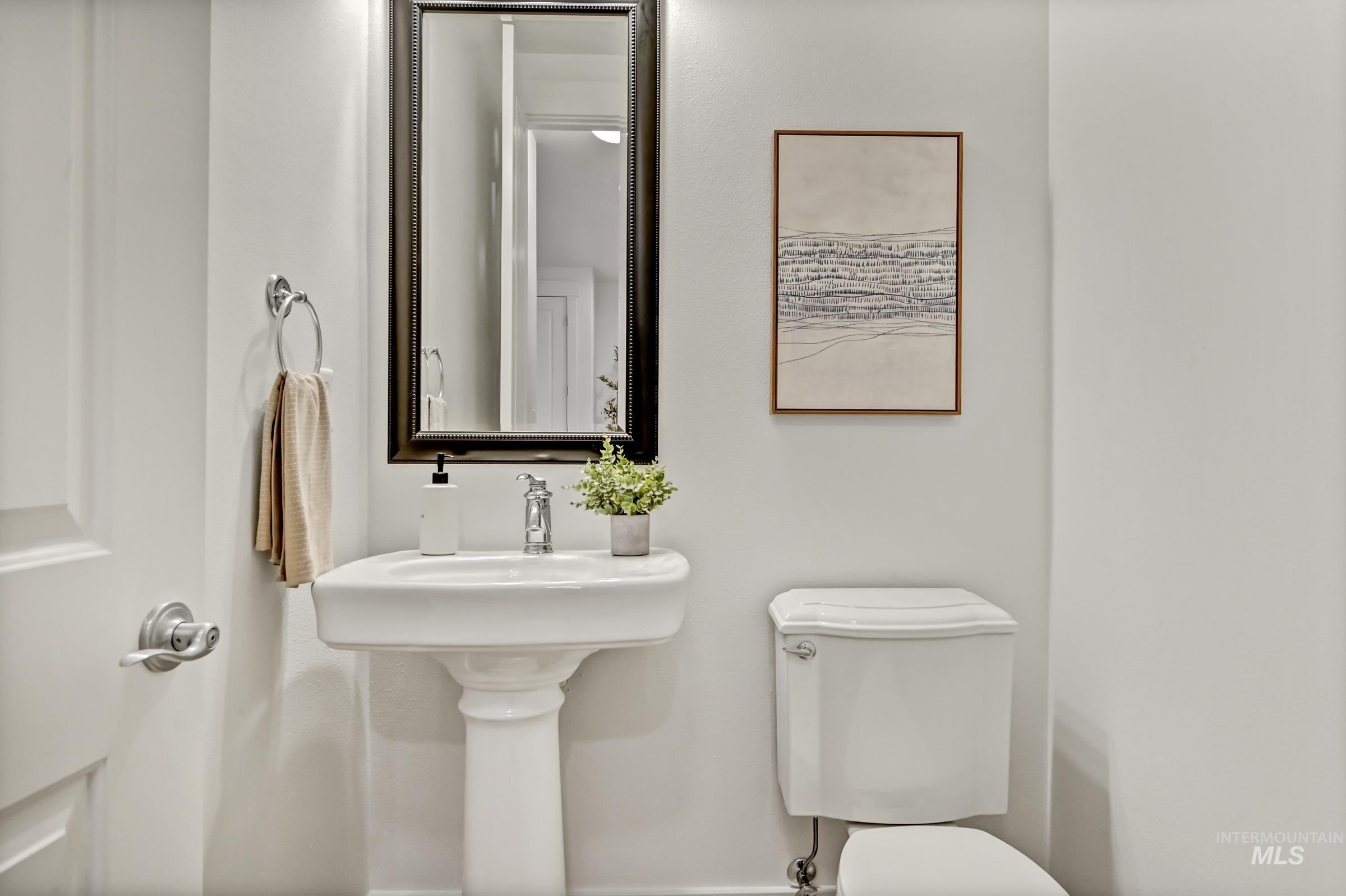 2476 North Bogus Basin Road Boise, ID 83702 - Photo 16 of 48 Main level half bathroom with pedestal sink and mirror. Clean and compact layout.