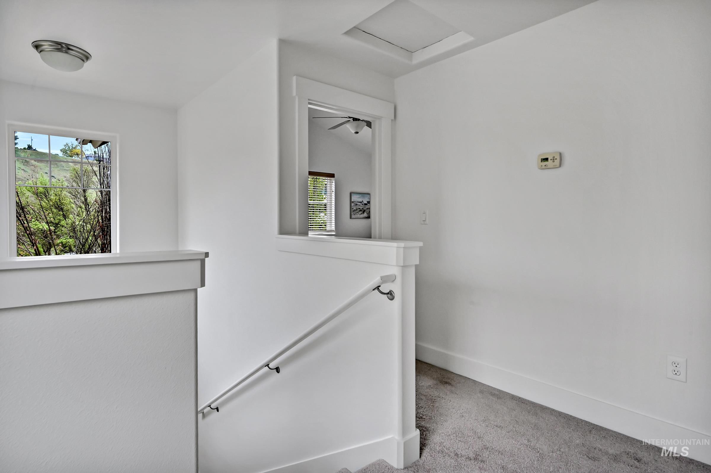 2476 North Bogus Basin Road Boise, ID 83702 - Photo 28 of 48 Stair landing and hallway with large windows and doors to both ensuites and the laundry room.