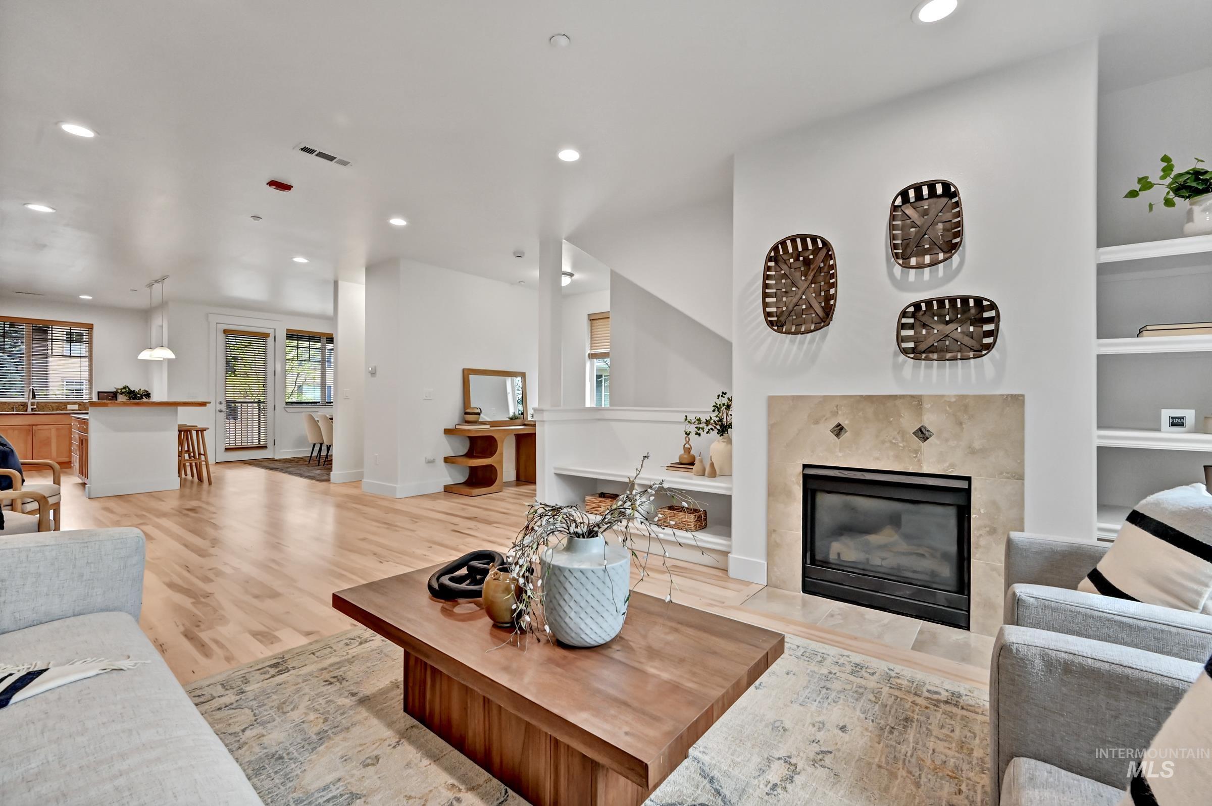 2476 North Bogus Basin Road Boise, ID 83702 - Photo 5 of 48 Open living and dining area with hardwood floors and a fireplace. Bright layout with natural light and functional flow.