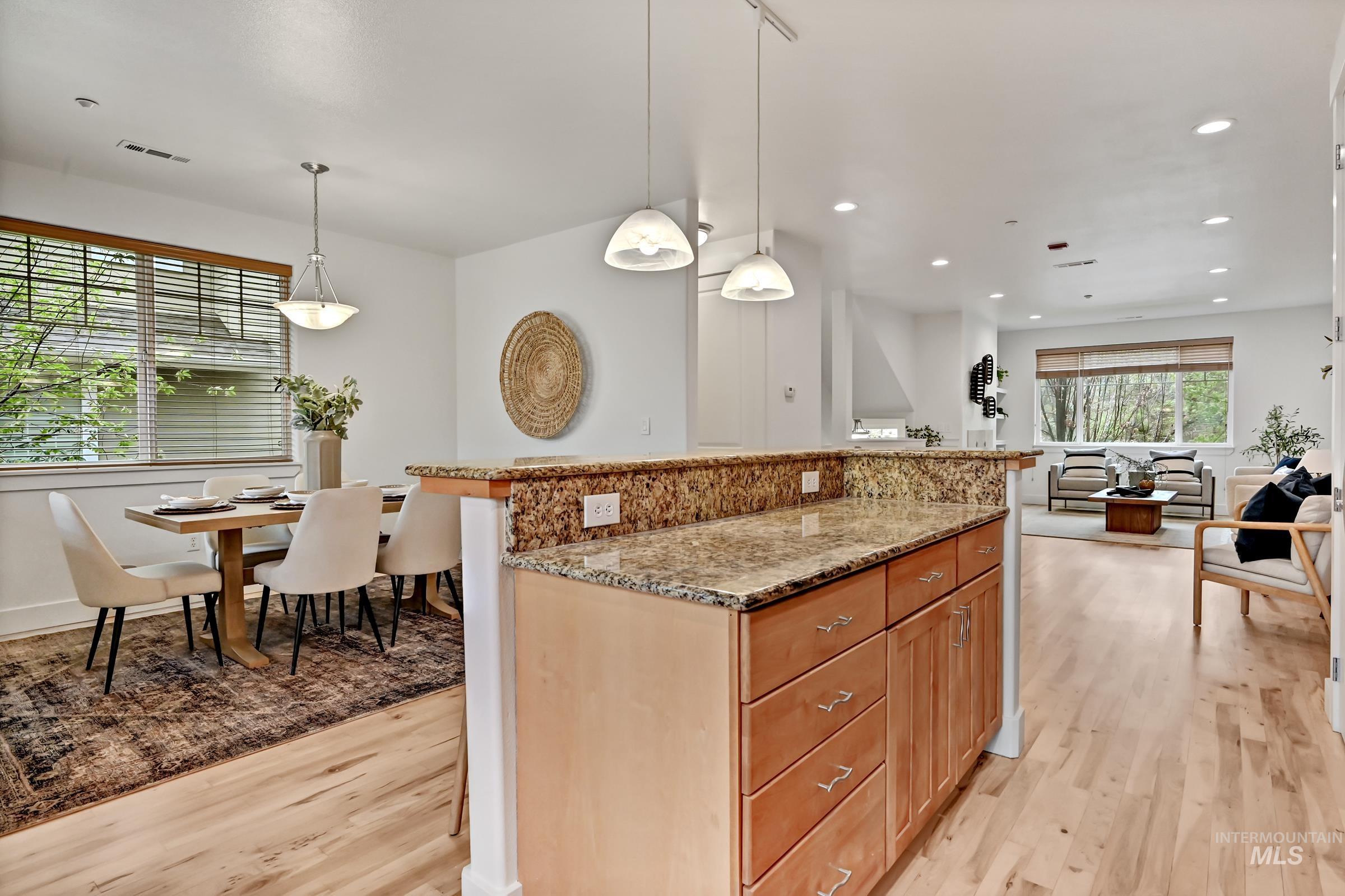2476 North Bogus Basin Road Boise, ID 83702 - Photo 10 of 48 Kitchen with granite counters, center island, and pendant lighting. Ample cabinetry. Open layout for gathering that leads to the dining area and deck.