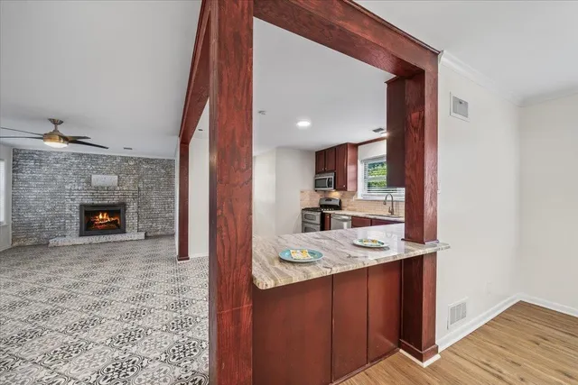 a large kitchen with stainless steel appliances granite countertop a stove refrigerator and cabinets