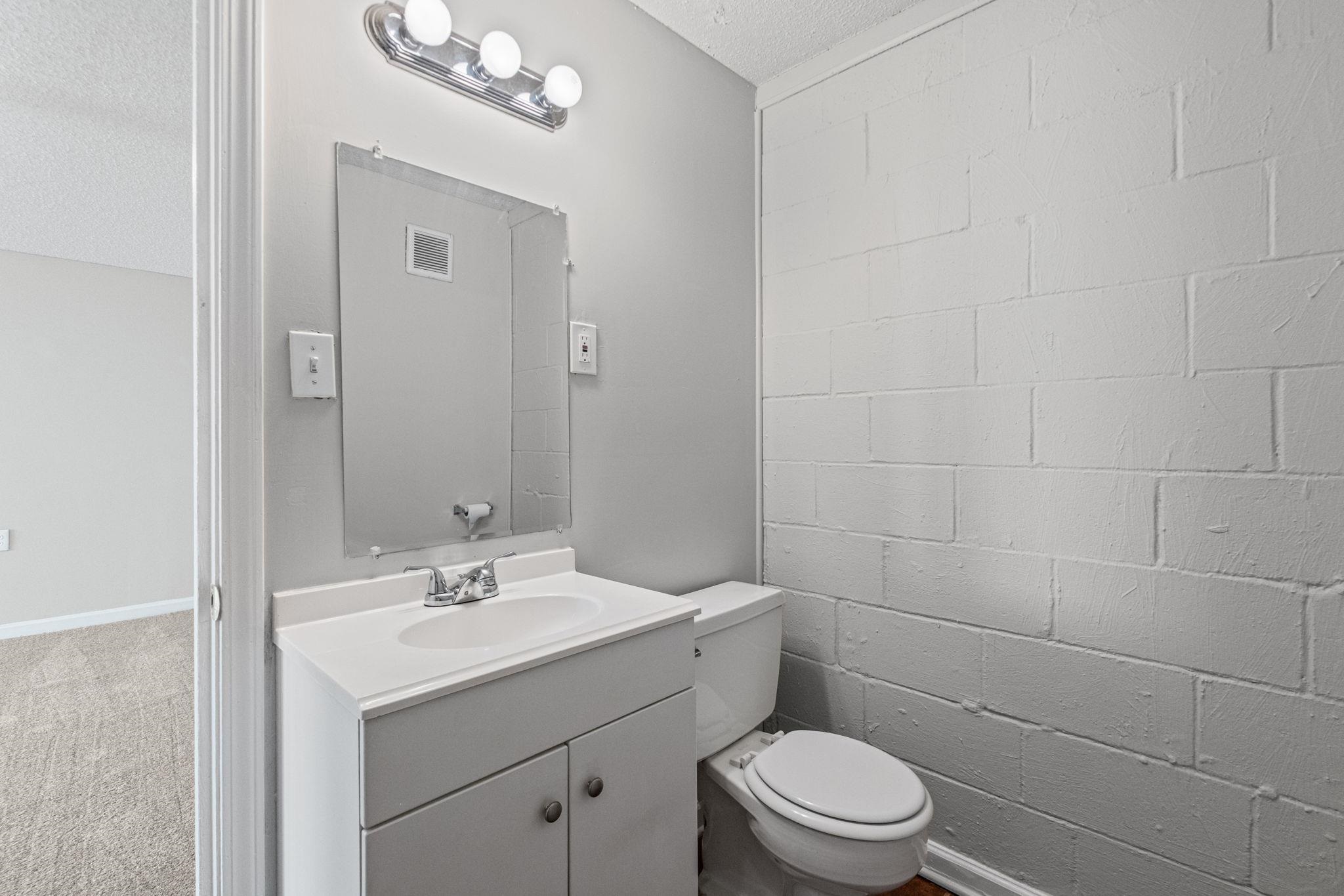 3580 Ramill Road Memphis, TN 38128 - Photo 17 of 24 Bathroom featuring concrete block wall, vanity, light carpet, and a textured ceiling