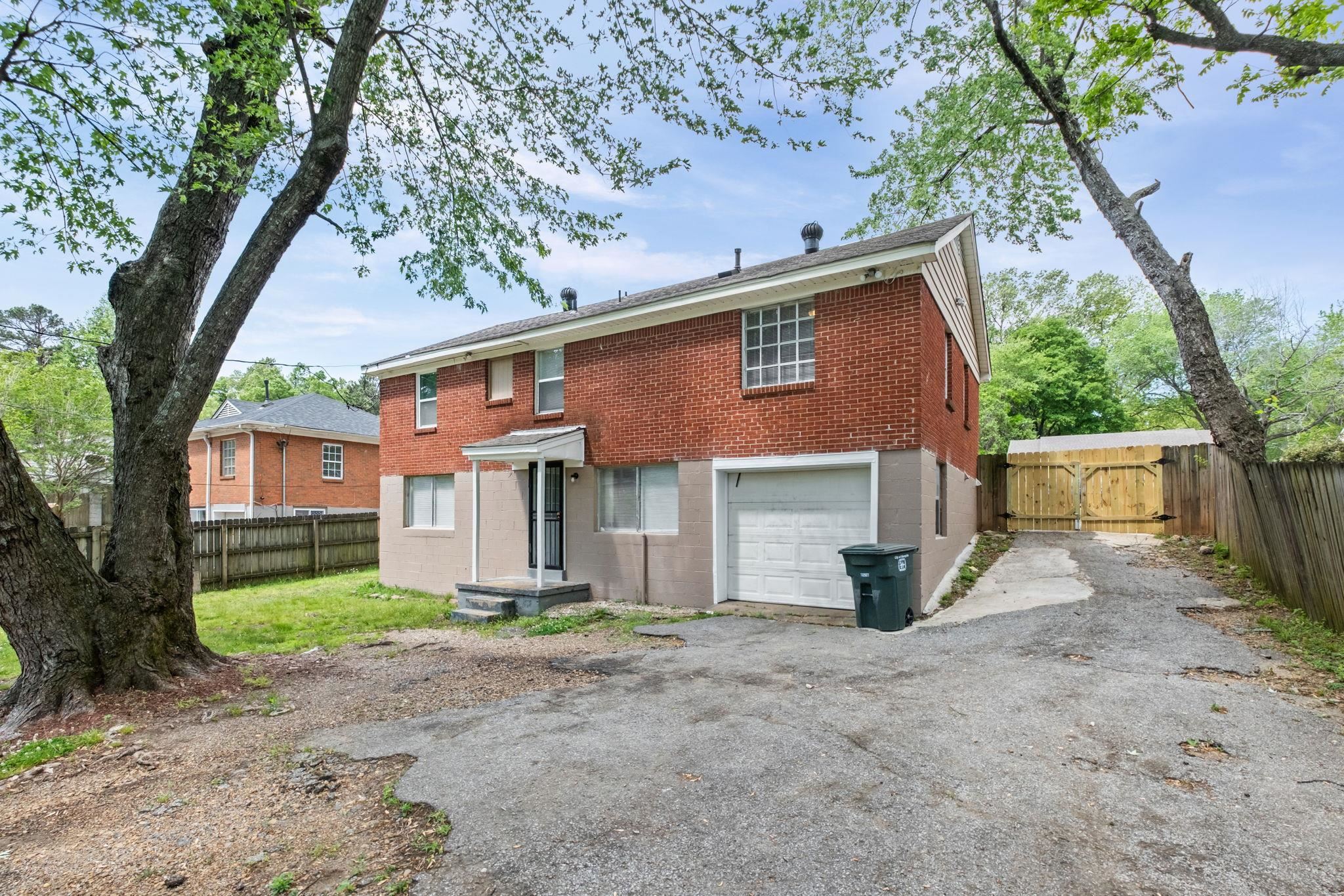3580 Ramill Road Memphis, TN 38128 - Photo 21 of 24 Rear view of property featuring driveway, a gate, brick siding, and an attached garage