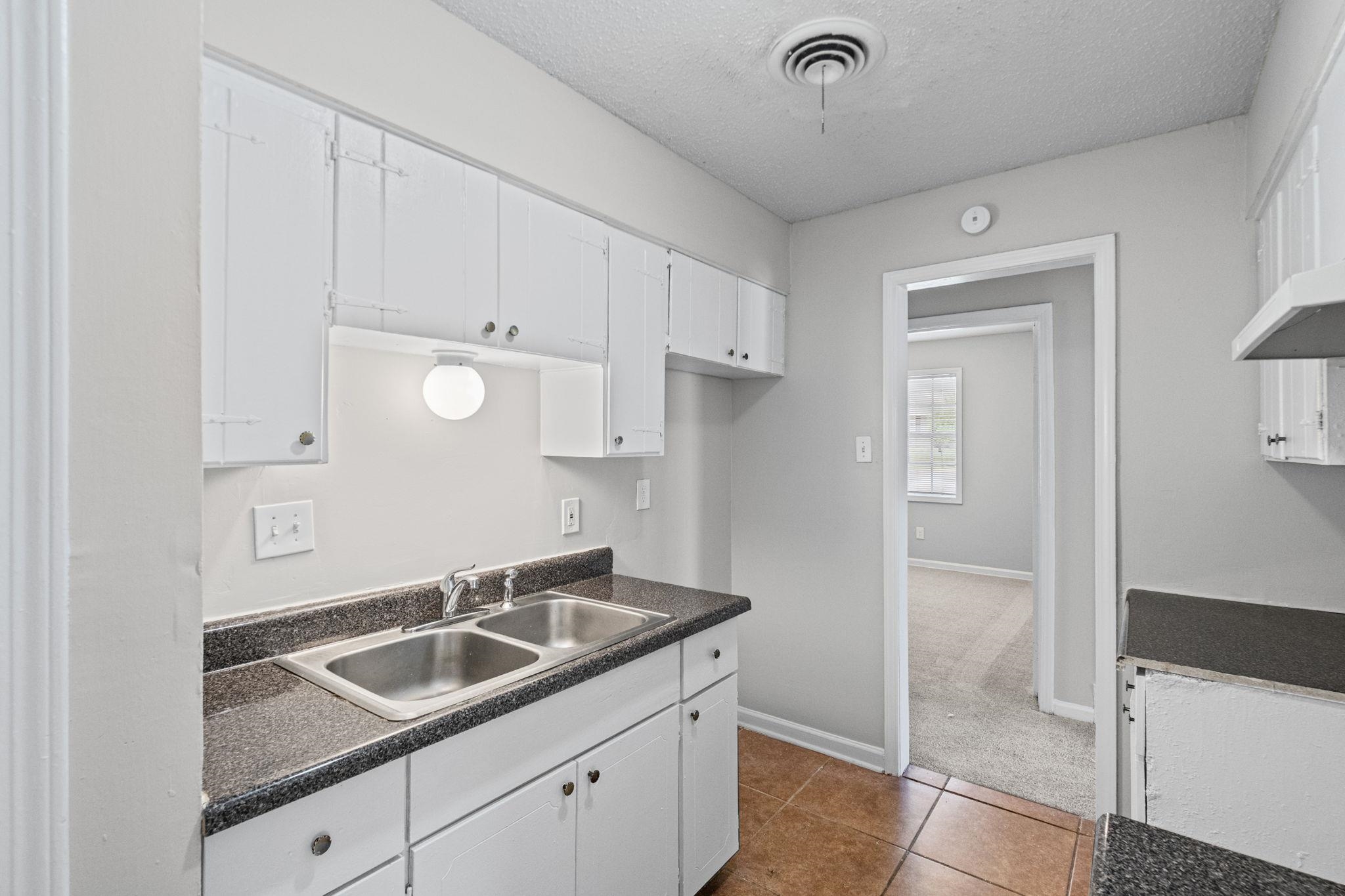 3580 Ramill Road Memphis, TN 38128 - Photo 7 of 24 Kitchen with dark countertops, white cabinets, a textured ceiling, and dark tile patterned floors
