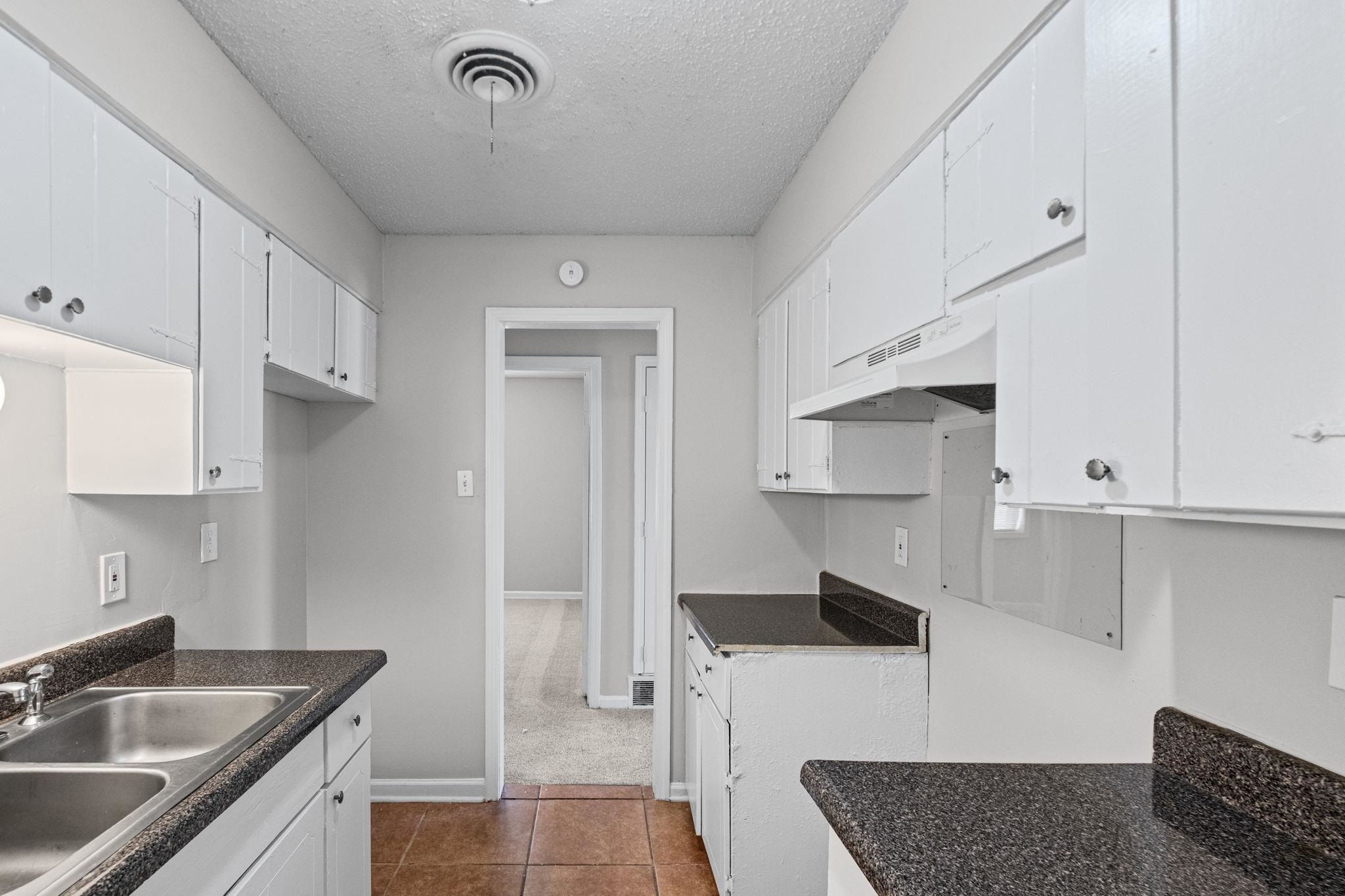 3580 Ramill Road Memphis, TN 38128 - Photo 8 of 24 Kitchen featuring white cabinetry, dark countertops, a textured ceiling, dark tile patterned flooring, and dark colored carpet