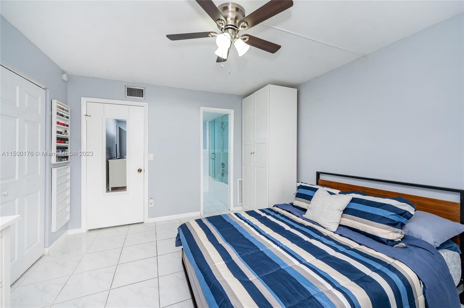 12239 Southwest 14th Lane, Unit 3401 Miami, FL 33184 - Photo 14 of 23 a bedroom with a bed and a chandelier