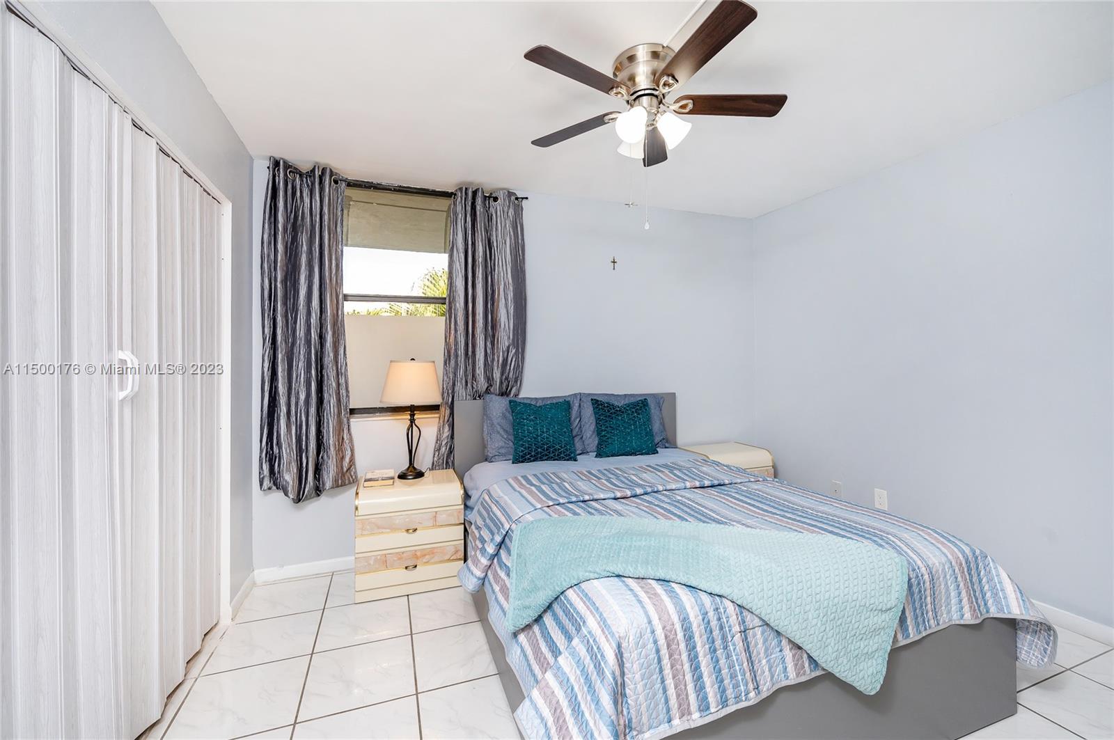 12239 Southwest 14th Lane, Unit 3401 Miami, FL 33184 - Photo 16 of 23 a bedroom with a large bed and a chandelier