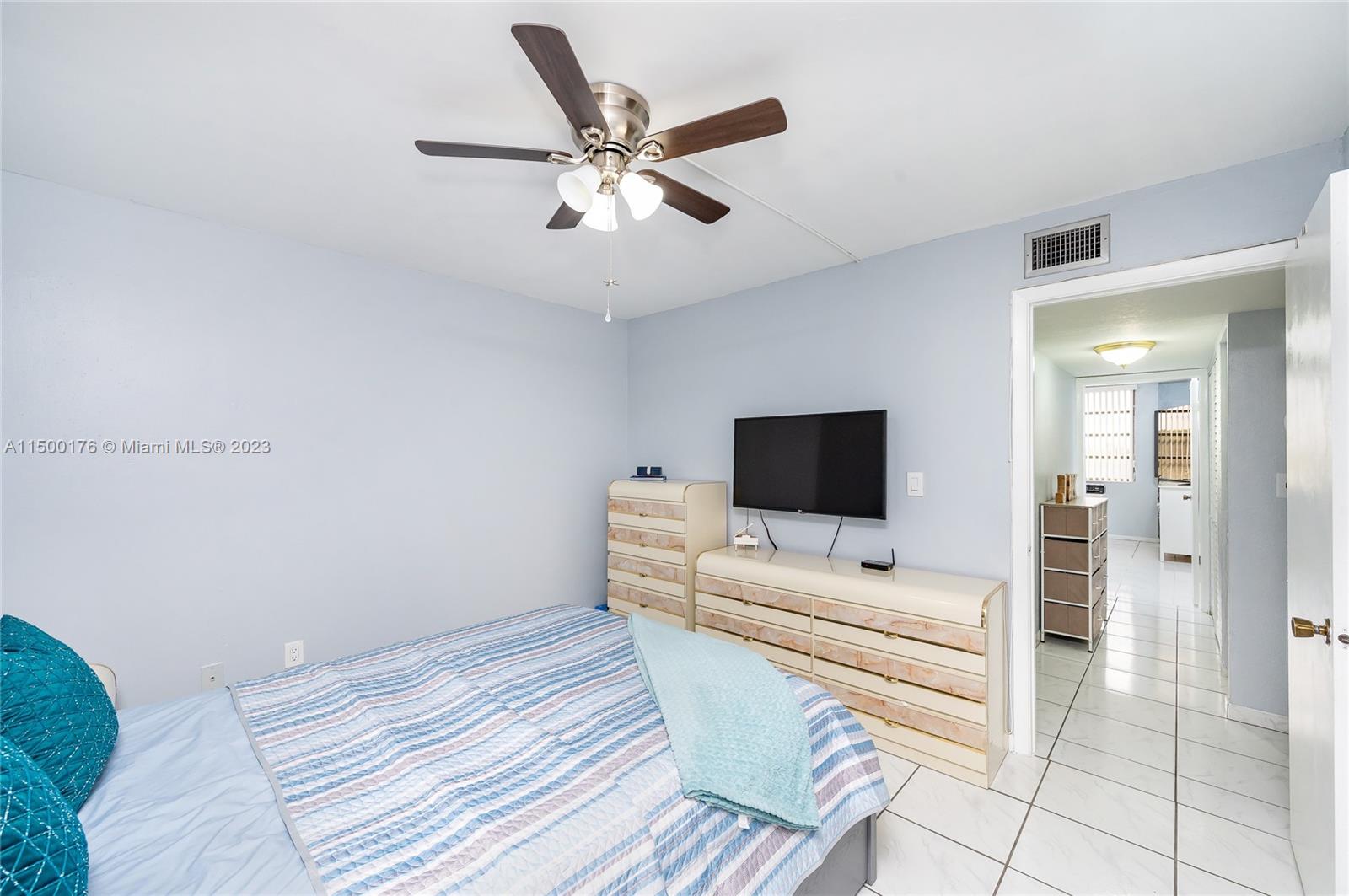 12239 Southwest 14th Lane, Unit 3401 Miami, FL 33184 - Photo 18 of 23 a bedroom with a bed and a flat screen tv