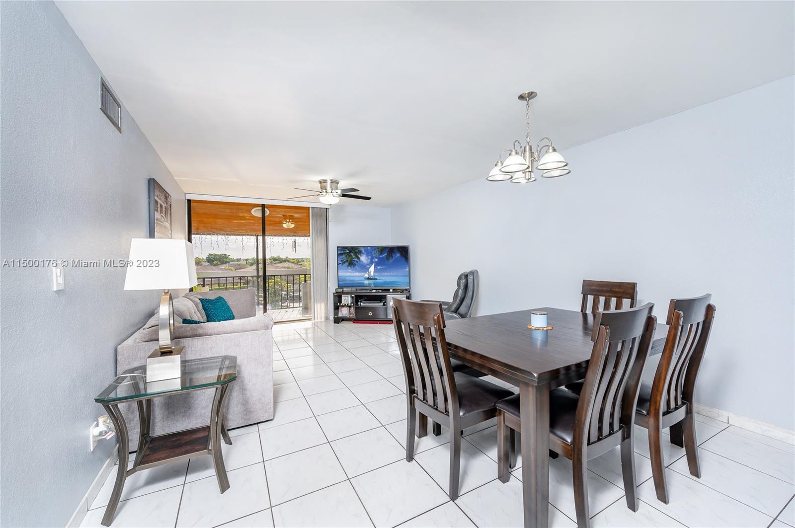 12239 Southwest 14th Lane, Unit 3401 Miami, FL 33184 - Photo 5 of 23 a view of a dining room with furniture and chandelier