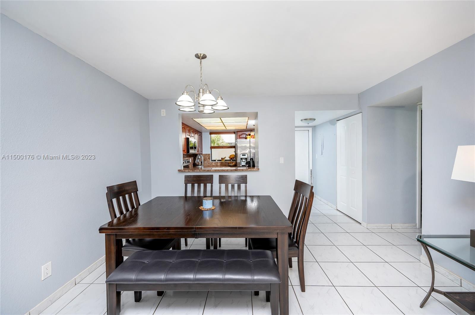12239 Southwest 14th Lane, Unit 3401 Miami, FL 33184 - Photo 6 of 23 a view of a dining room with furniture and chandelier