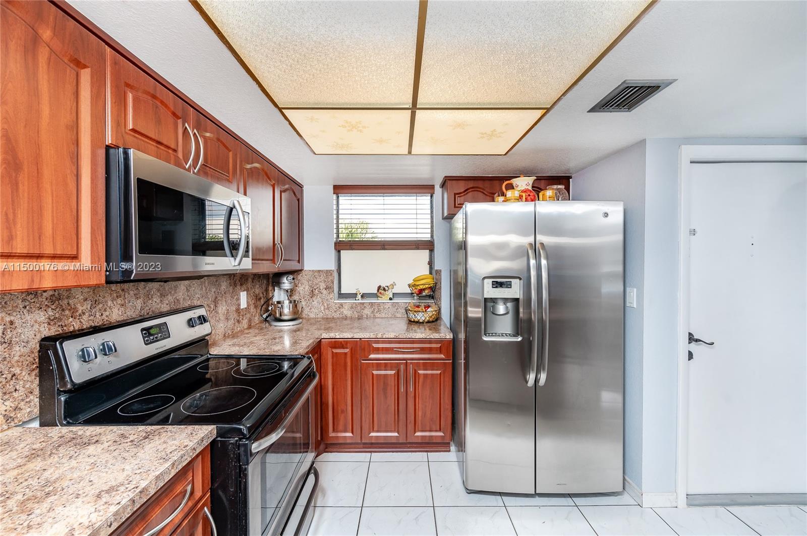 12239 Southwest 14th Lane, Unit 3401 Miami, FL 33184 - Photo 7 of 23 a kitchen with stainless steel appliances granite countertop a stove a refrigerator and a sink