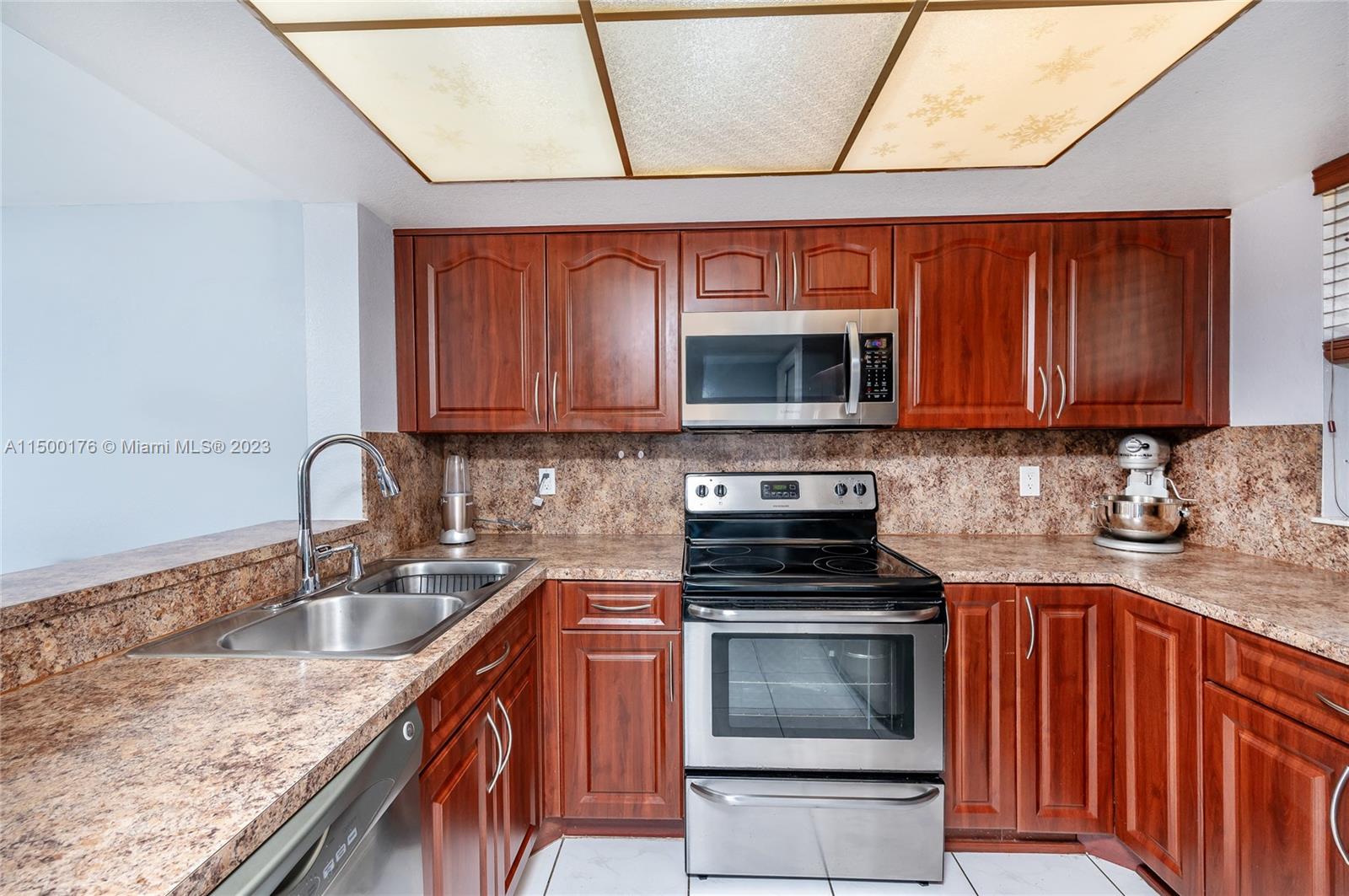 12239 Southwest 14th Lane, Unit 3401 Miami, FL 33184 - Photo 8 of 23 a kitchen with stainless steel appliances granite countertop a stove sink microwave and cabinets