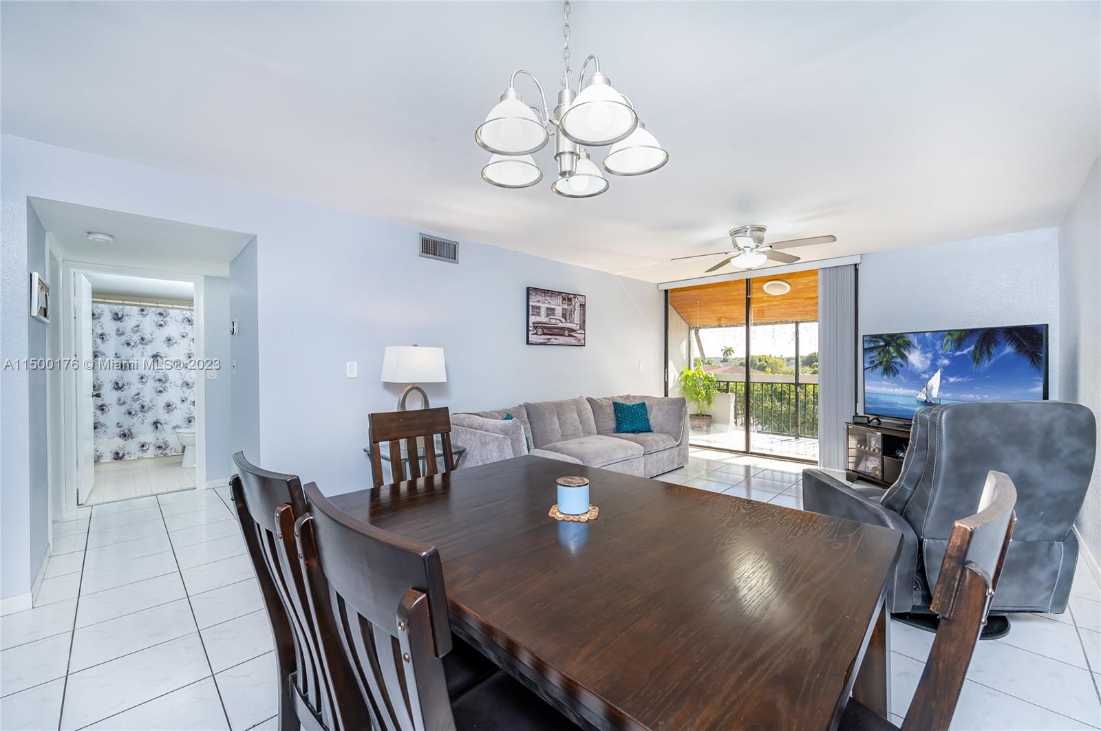 12239 Southwest 14th Lane, Unit 3401 Miami, FL 33184 - Photo 10 of 23 a view of a dining room with furniture a chandelier and wooden floor