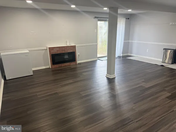 an empty room with wooden floor and fireplace