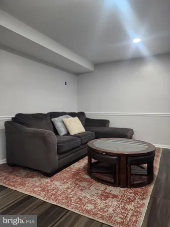 a living room with a couch and a stove with wooden floor