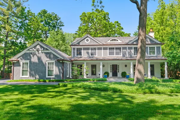 a front view of a house with a garden and trees