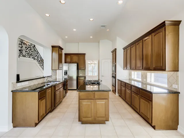 a large kitchen with stainless steel appliances lots of counter top space