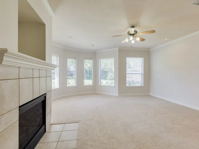 a view of an empty room with a fireplace and a window