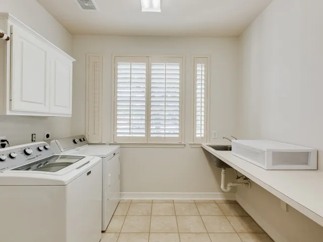 a utility room with sink dryer and washer