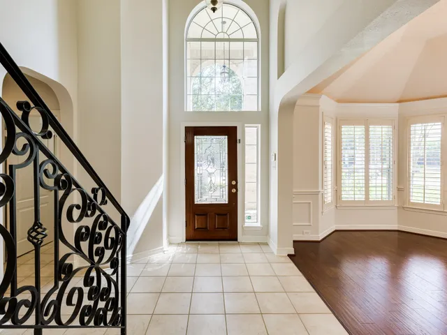 wooden floor with an entryway in a hall with a window