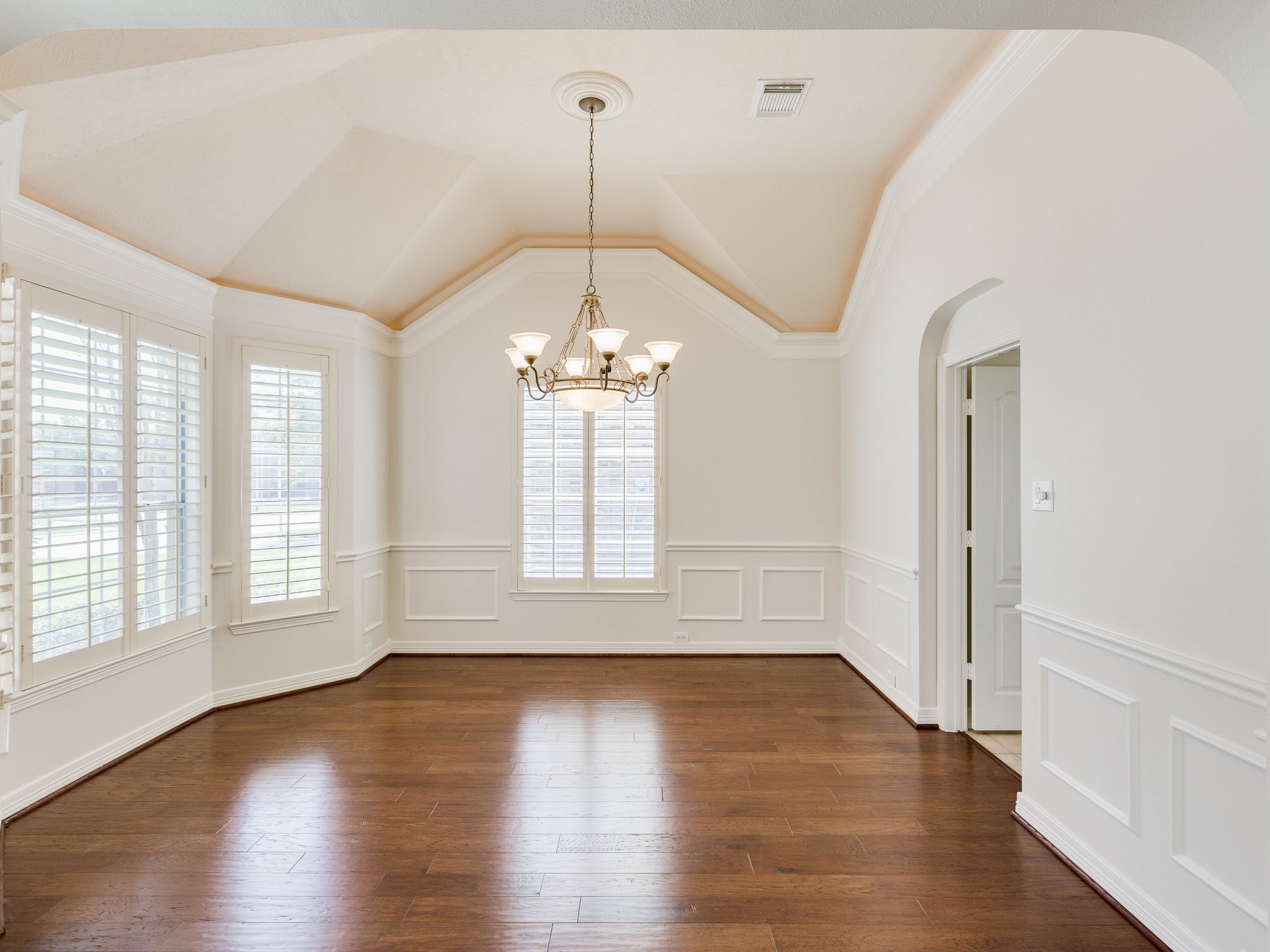 6327 Collina Springs Court Houston, TX 77041 - Photo 7 of 35 an empty room with wooden floor chandelier and windows