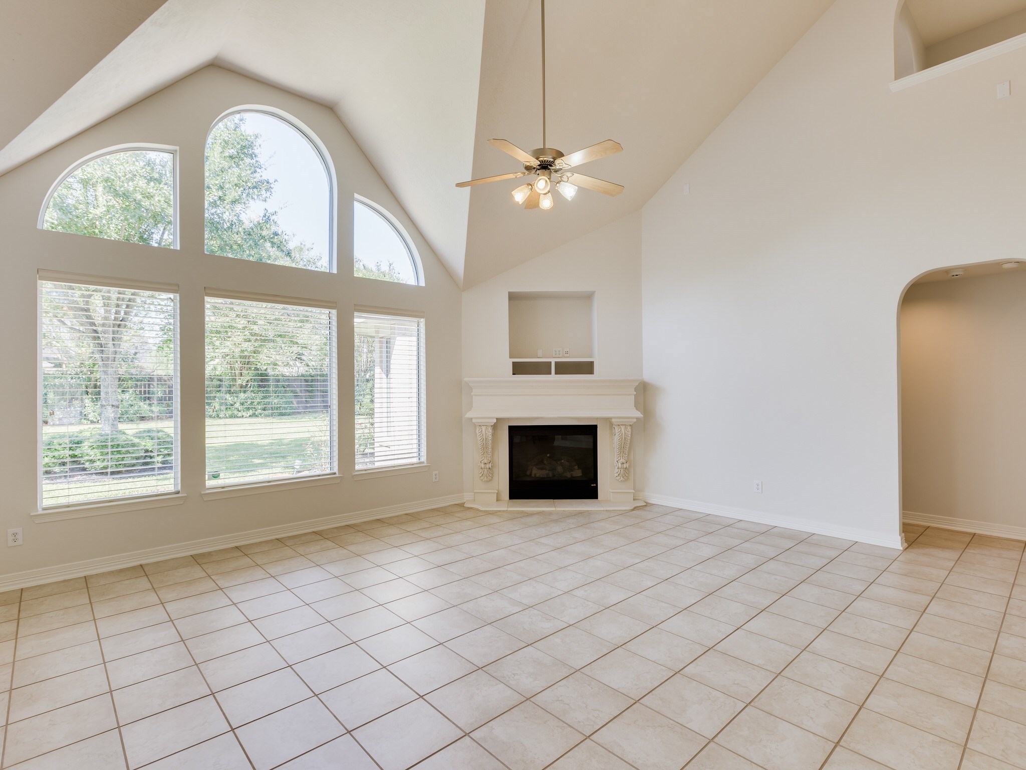 6327 Collina Springs Court Houston, TX 77041 - Photo 8 of 35 an empty room with windows chandelier fan and fireplace