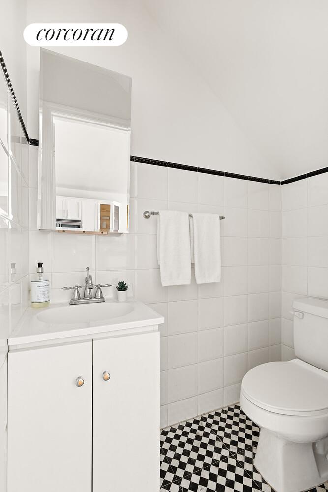 963 Kent Avenue, Unit D2 Brooklyn, NY 11205 - Photo 7 of 9 a bathroom with a sink a toilet and a mirror