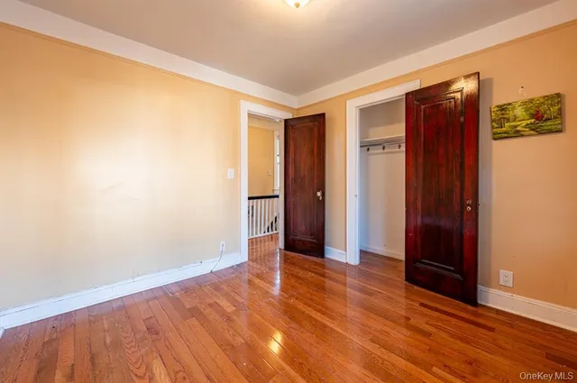 an empty room with wooden floor and closet