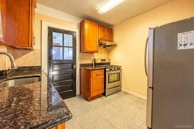 a kitchen with stainless steel appliances granite countertop a refrigerator and a stove