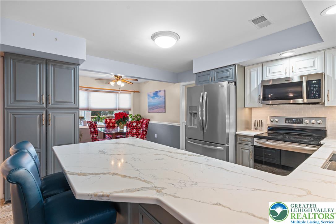 2702 Northampton Street Bethlehem, PA 18020 - Photo 17 of 51 a kitchen with stainless steel appliances kitchen island granite countertop a refrigerator a stove top oven a sink dishwasher and white cabinets with wooden floor