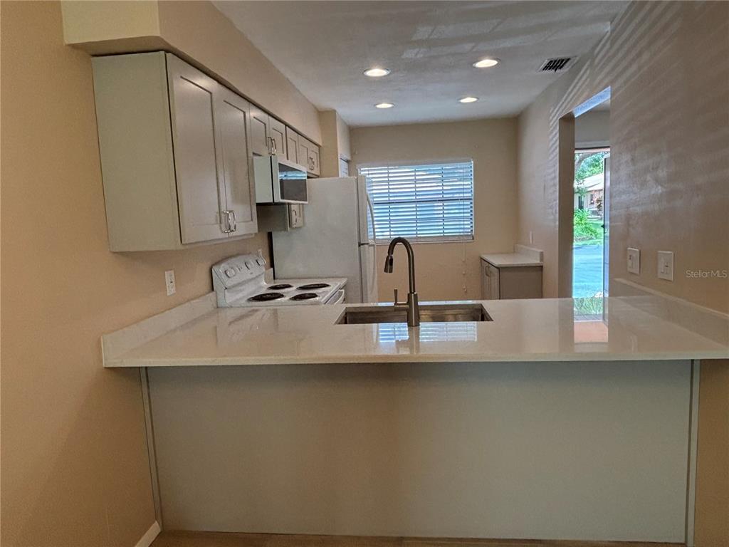 13250 Ridge Road, Unit 16 Largo, FL 33778 - Photo 11 of 32 a view of kitchen with kitchen island a sink a stove and a window