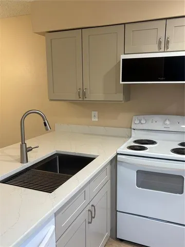 a kitchen with a sink a stove and cabinets