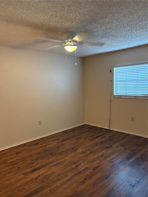 13250 Ridge Road, Unit 16 Largo, FL 33778 - Photo 14 of 28 a view of an empty room with wooden floor and fan