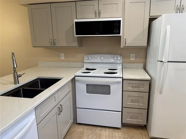 a kitchen with white cabinets and white appliances