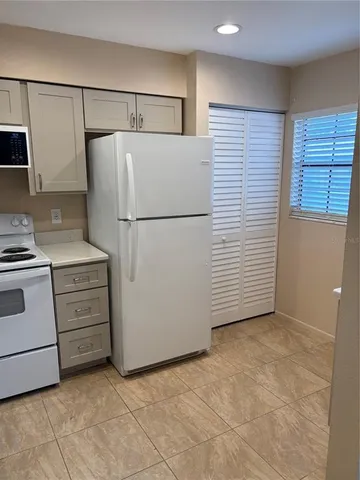 a kitchen with cabinets and white appliances